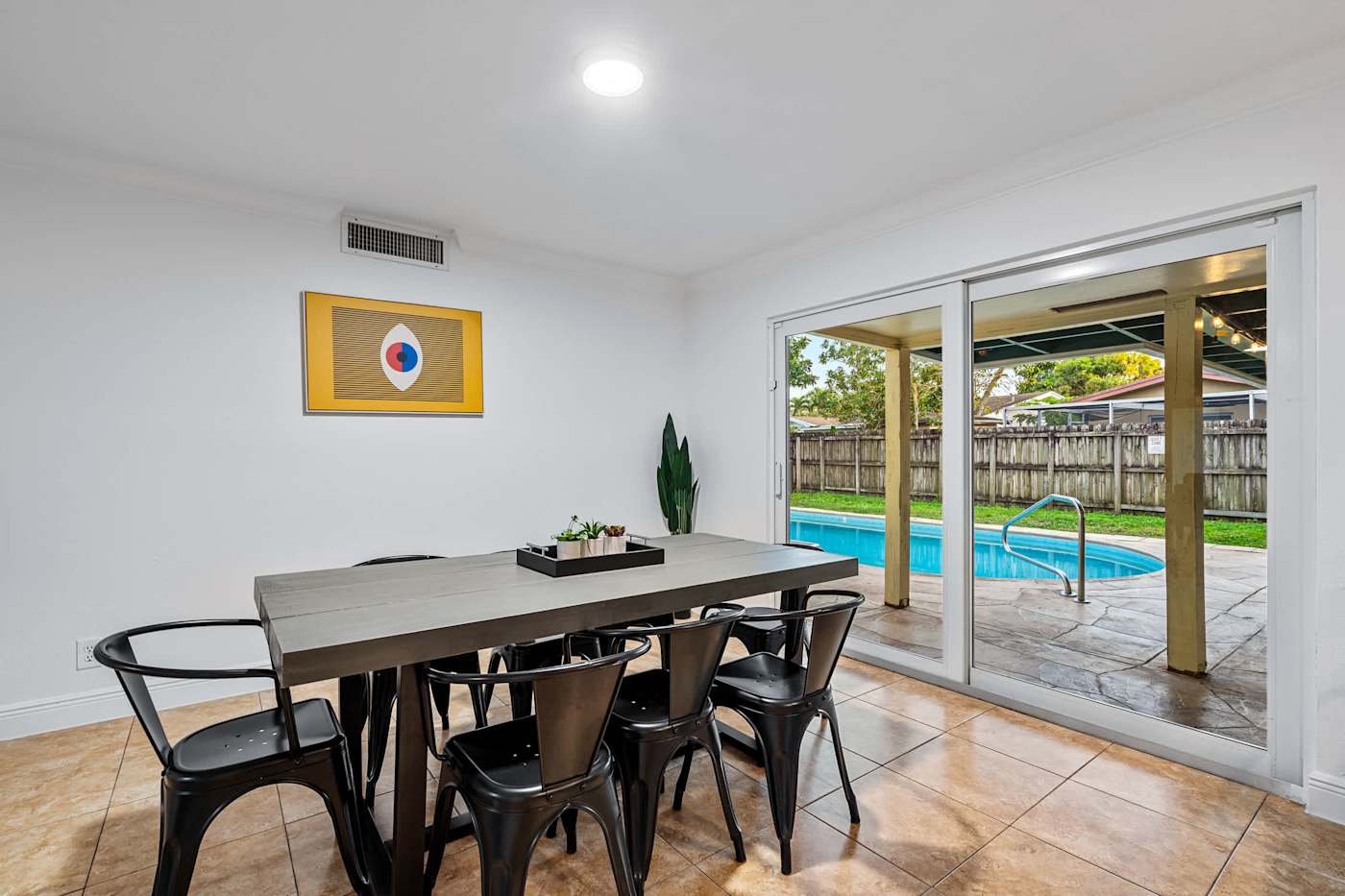 The Game House: Dining table for eight beside the sliding doors to the pool