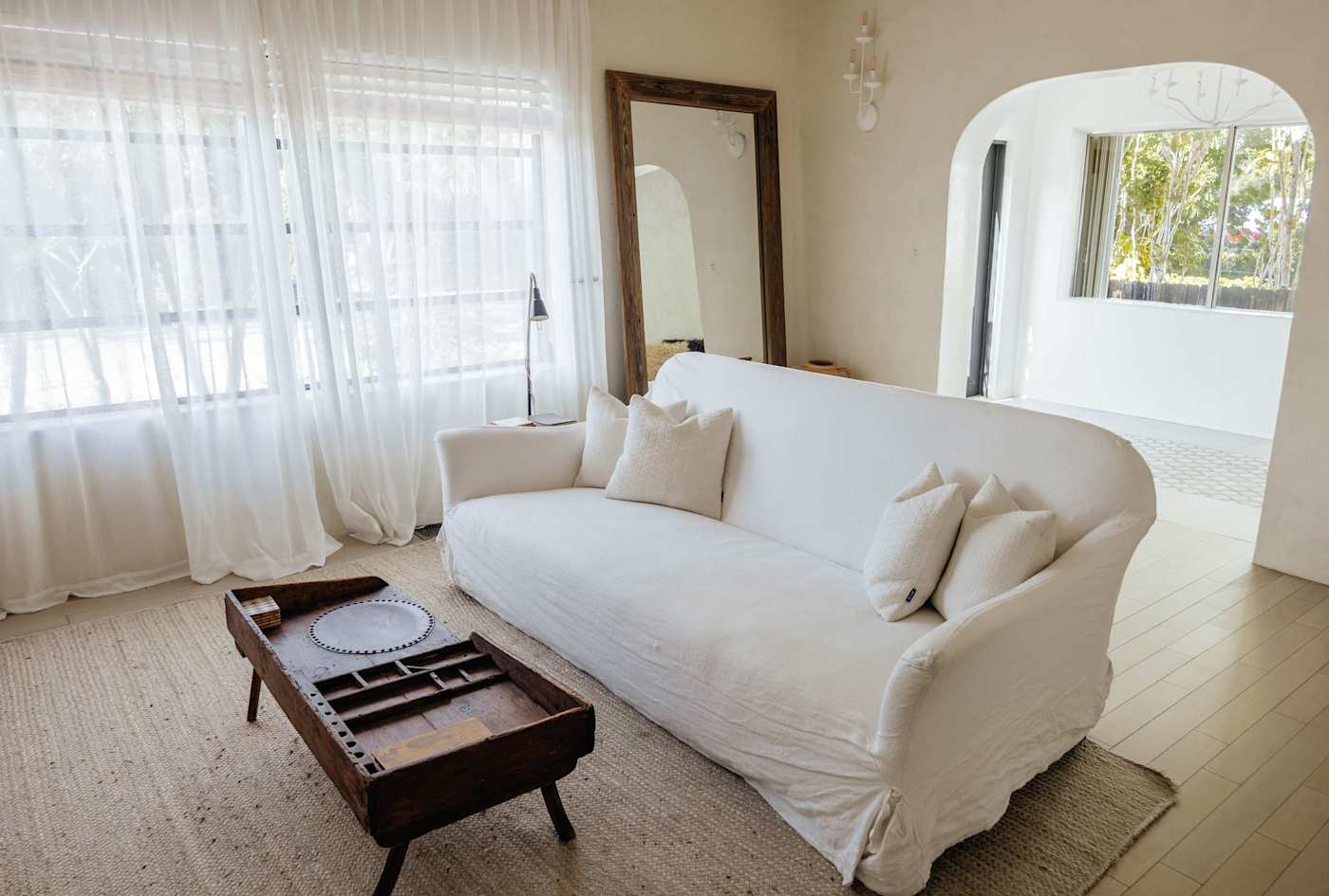 Sol y Sombra: Living room with custom couch, full length custom mirror and arched entry way