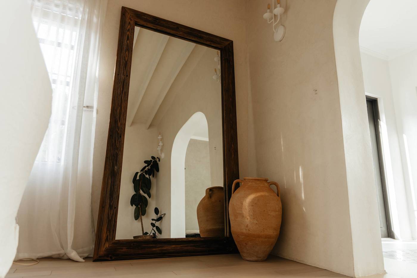 Sol y Sombra: Floor length mirror in the living room featuring natural light and custom pottery