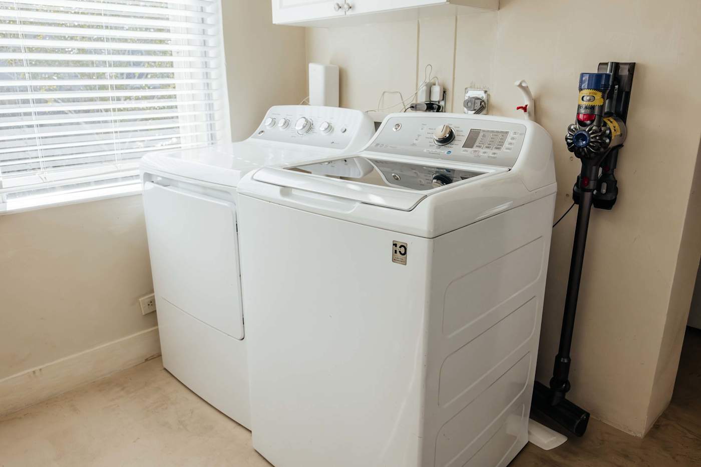 Sol y Sombra: Laundry room with a full size washer and dryer and Dyson Vacuum