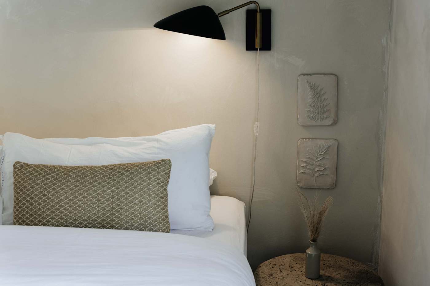 Sol y Sombra: King sized bedroom with rustic art pieces and nightstand