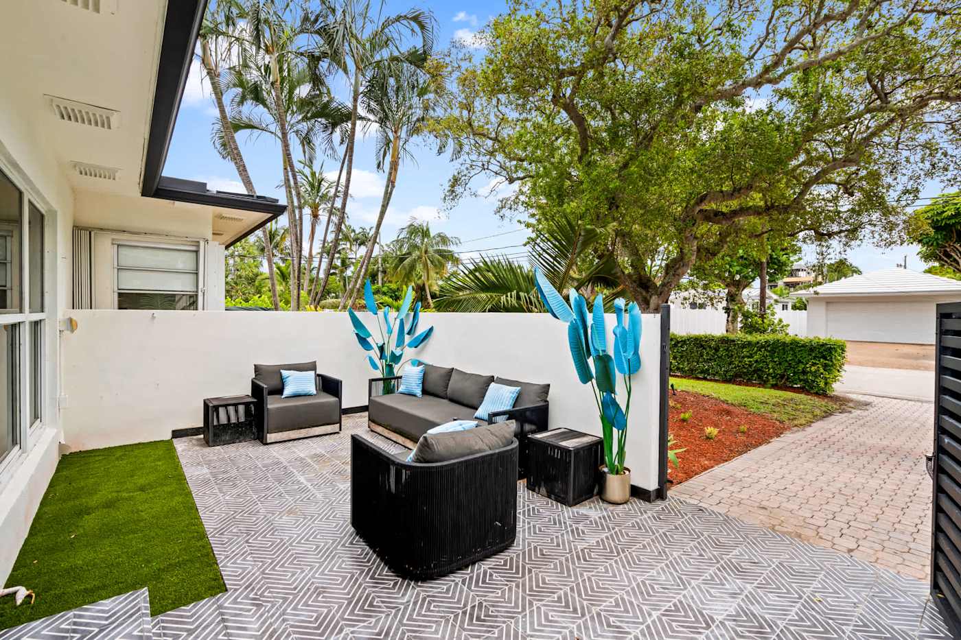 Beach Pop House: Side patio with outdoor sofa and sculpture