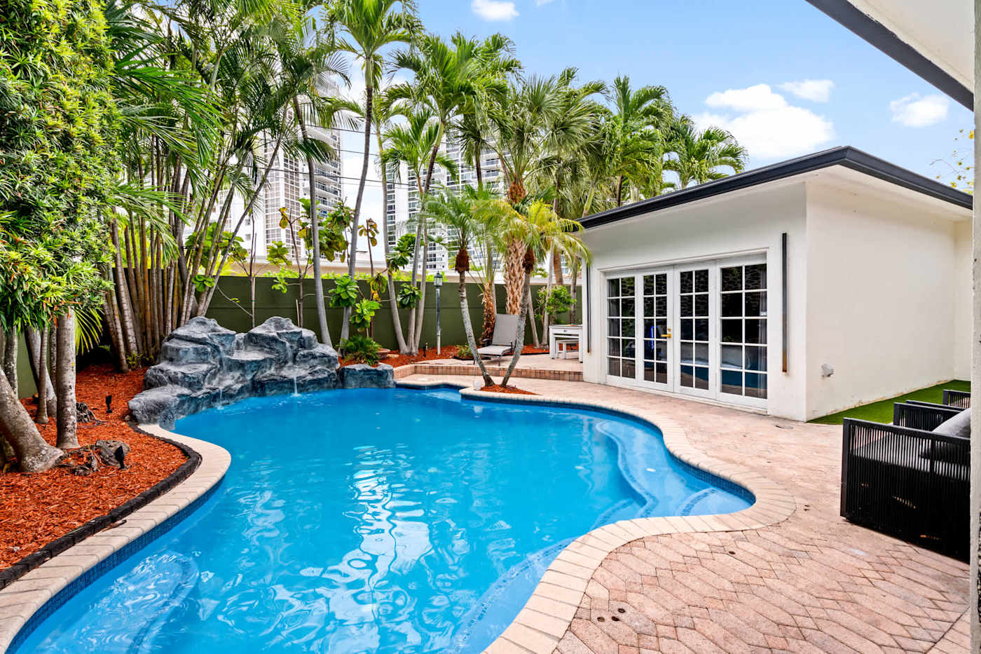 Beach Pop House: Heated pool in daylight, with french doors to the house