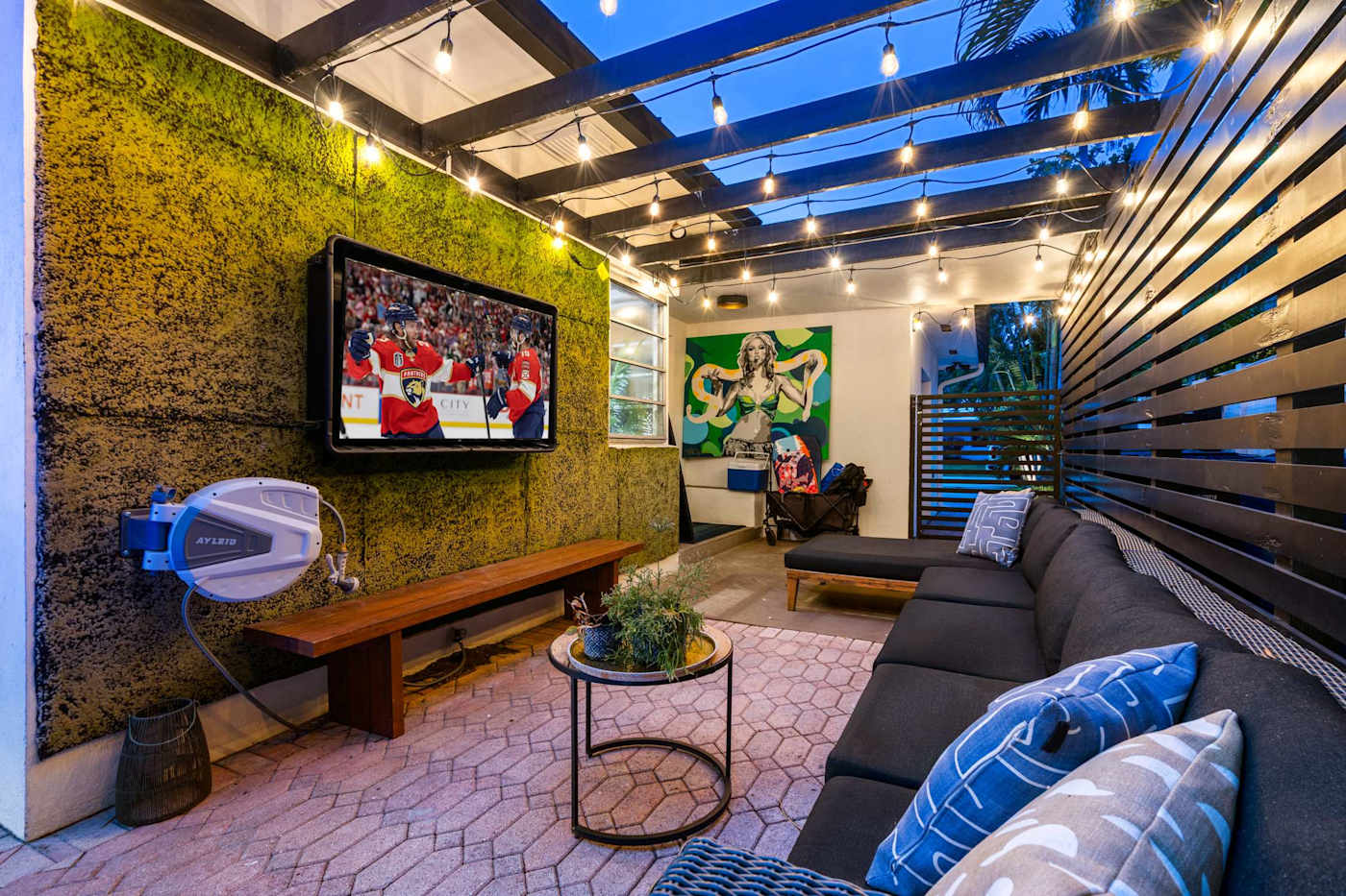 Beach Pop House: Outdoor lounge with mounted TV and moss wall, for watching by the pool