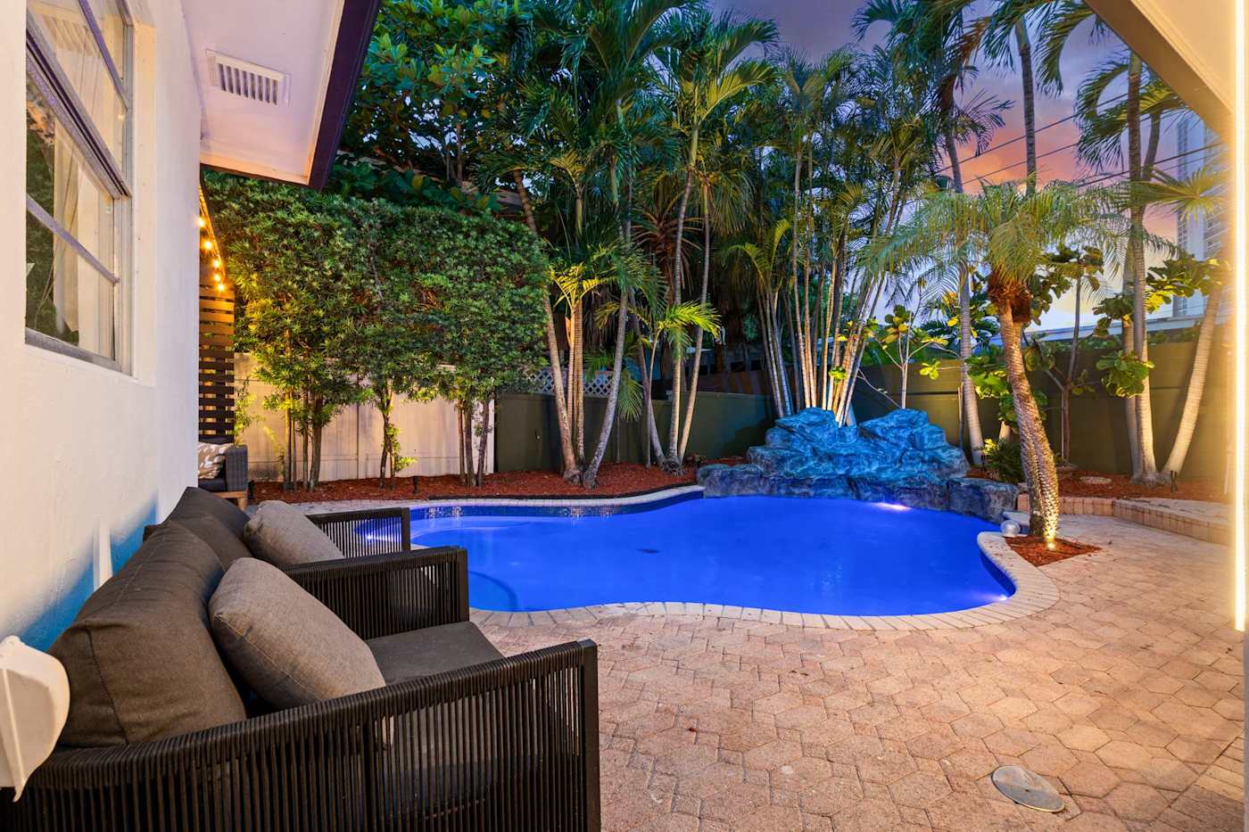 Beach Pop House: Heated pool seen from the covered lounge at dusk