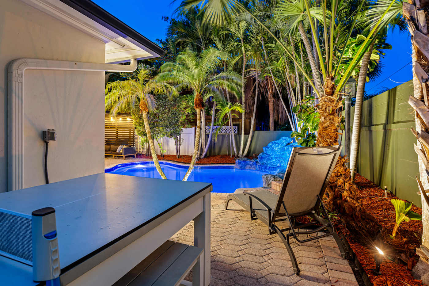 Beach Pop House: Poolside table at dusk