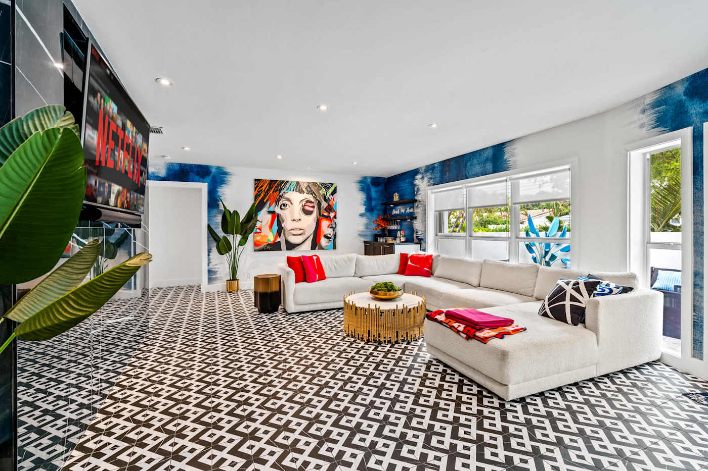 Beach Pop House: Living room with white sectional, patterned floor and bold artwork