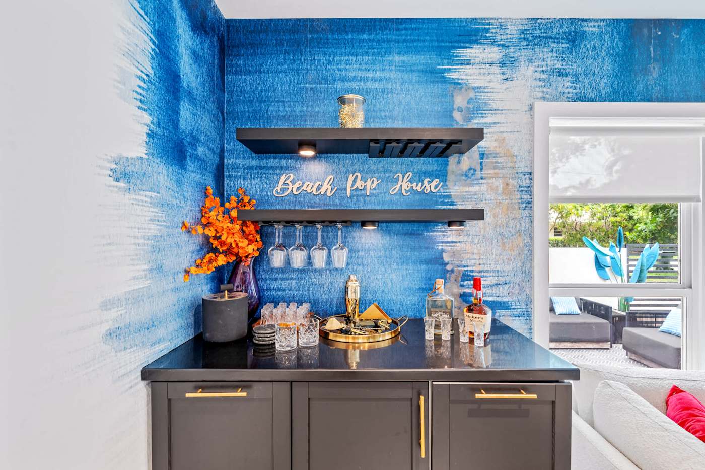 Beach Pop House: Wet bar with shelving and glassware, under the house sign