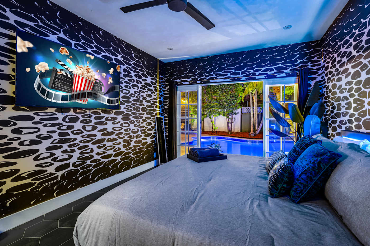 Beach Pop House: Bedroom with patterned feature wall and doors onto the pool deck
