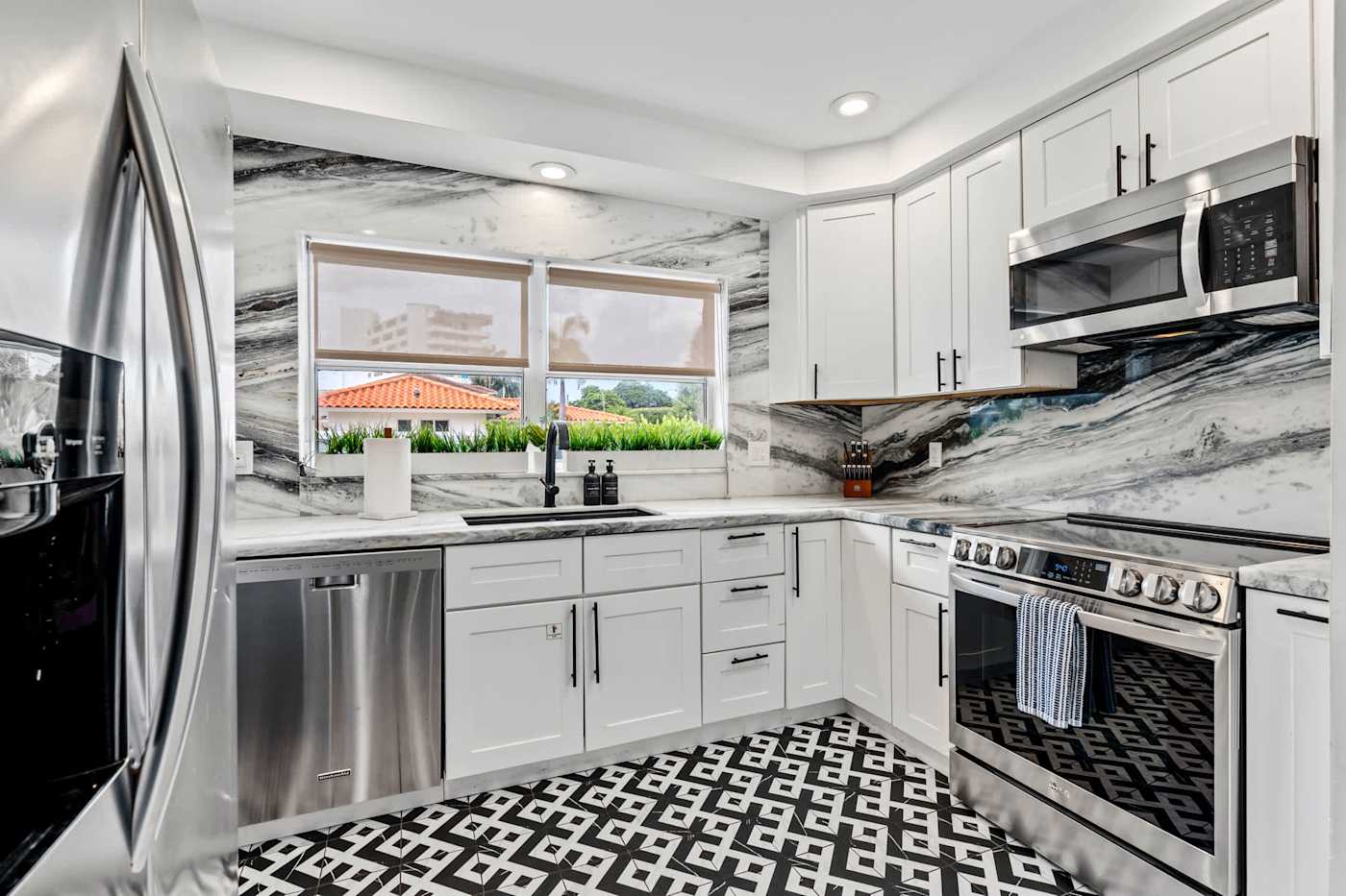 Beach Pop House: Kitchen with marble splashback, stainless appliances and full size range