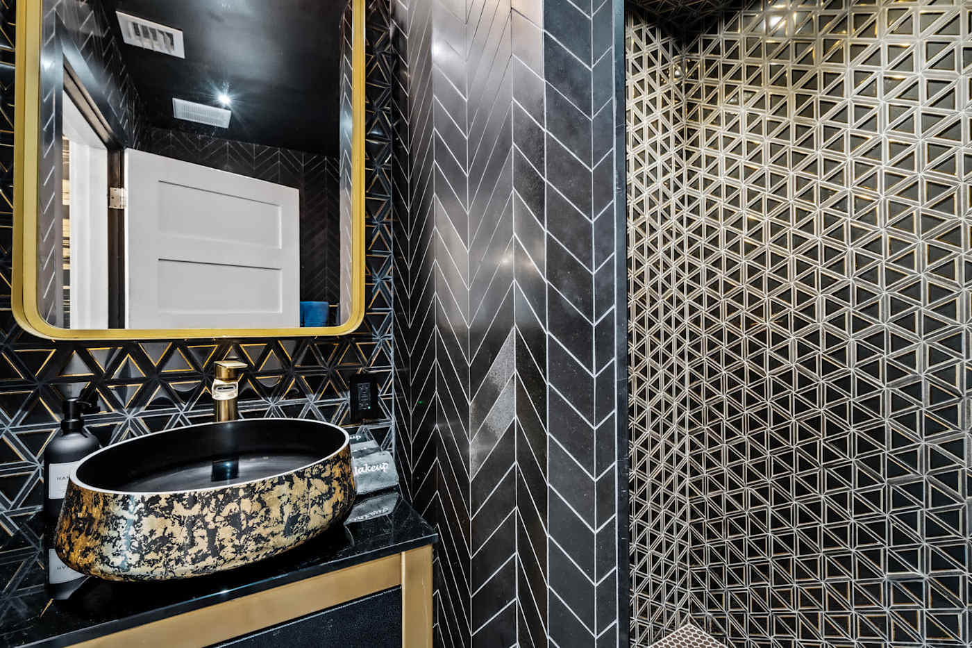 Beach Pop House: Bathroom with black herringbone tile, gold fittings and vessel basin