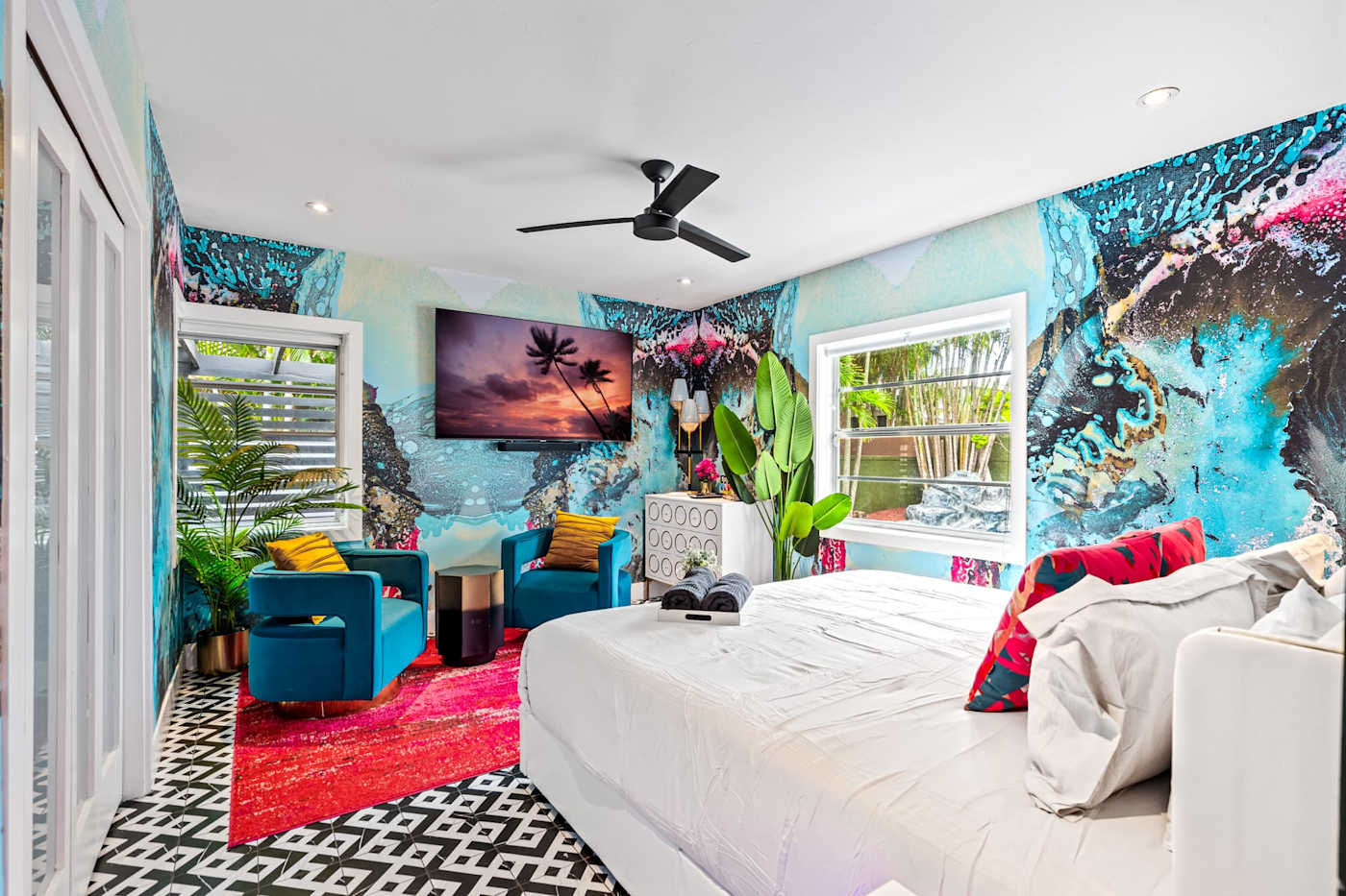 Beach Pop House: Bright bedroom with seating and tropical artwork