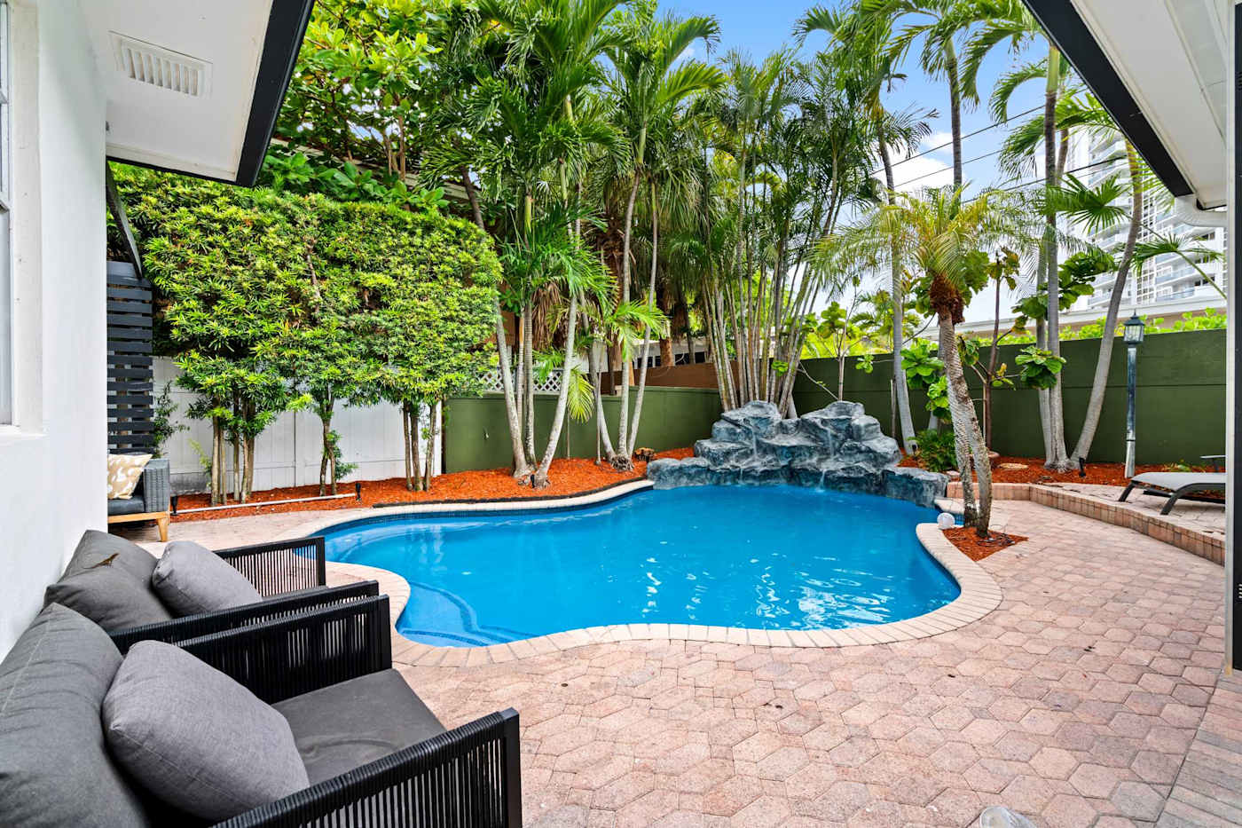 Beach Pop House: Heated pool in daylight with the covered lounge alongside