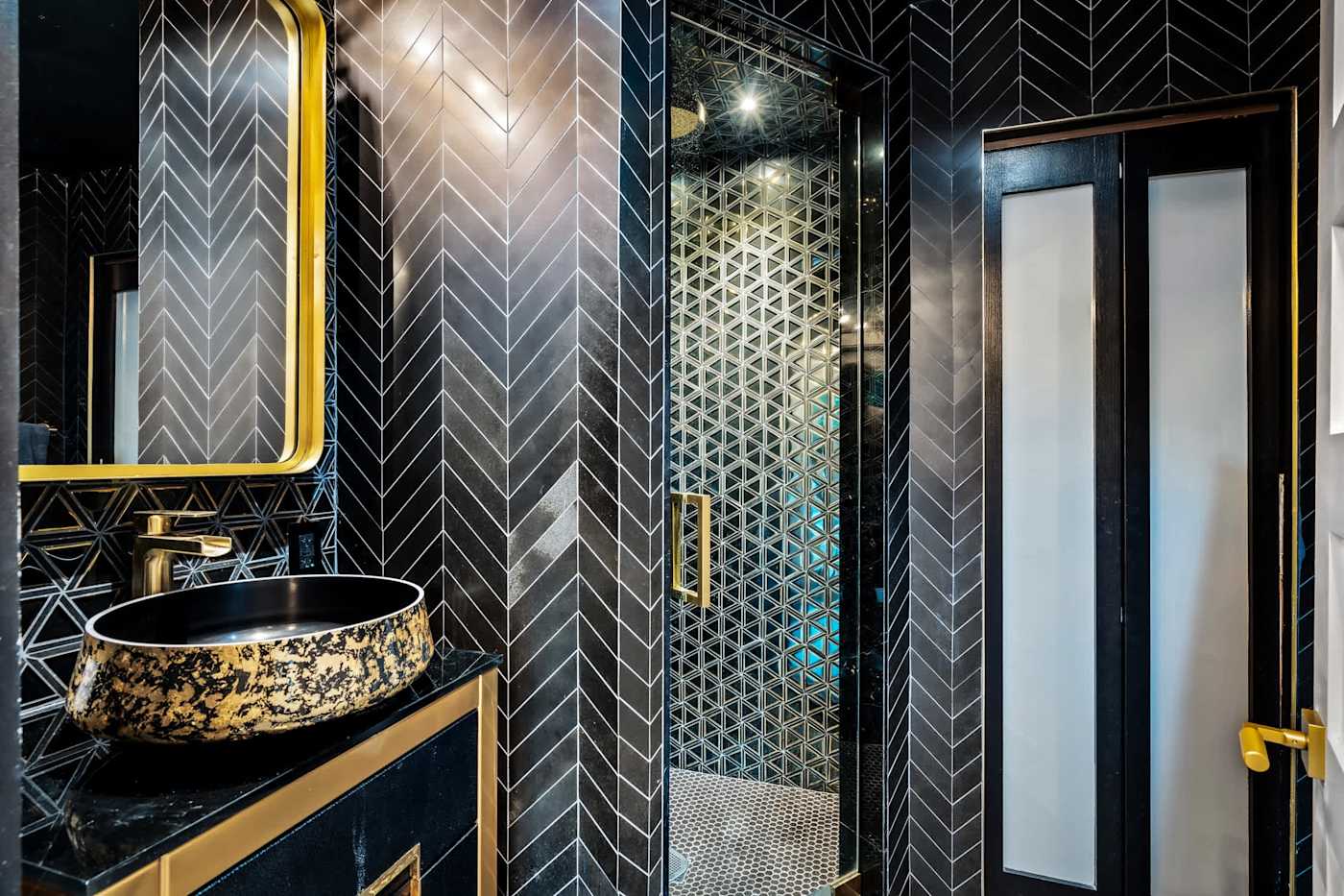 Beach Pop House: Bathroom with black herringbone tile and gold basin