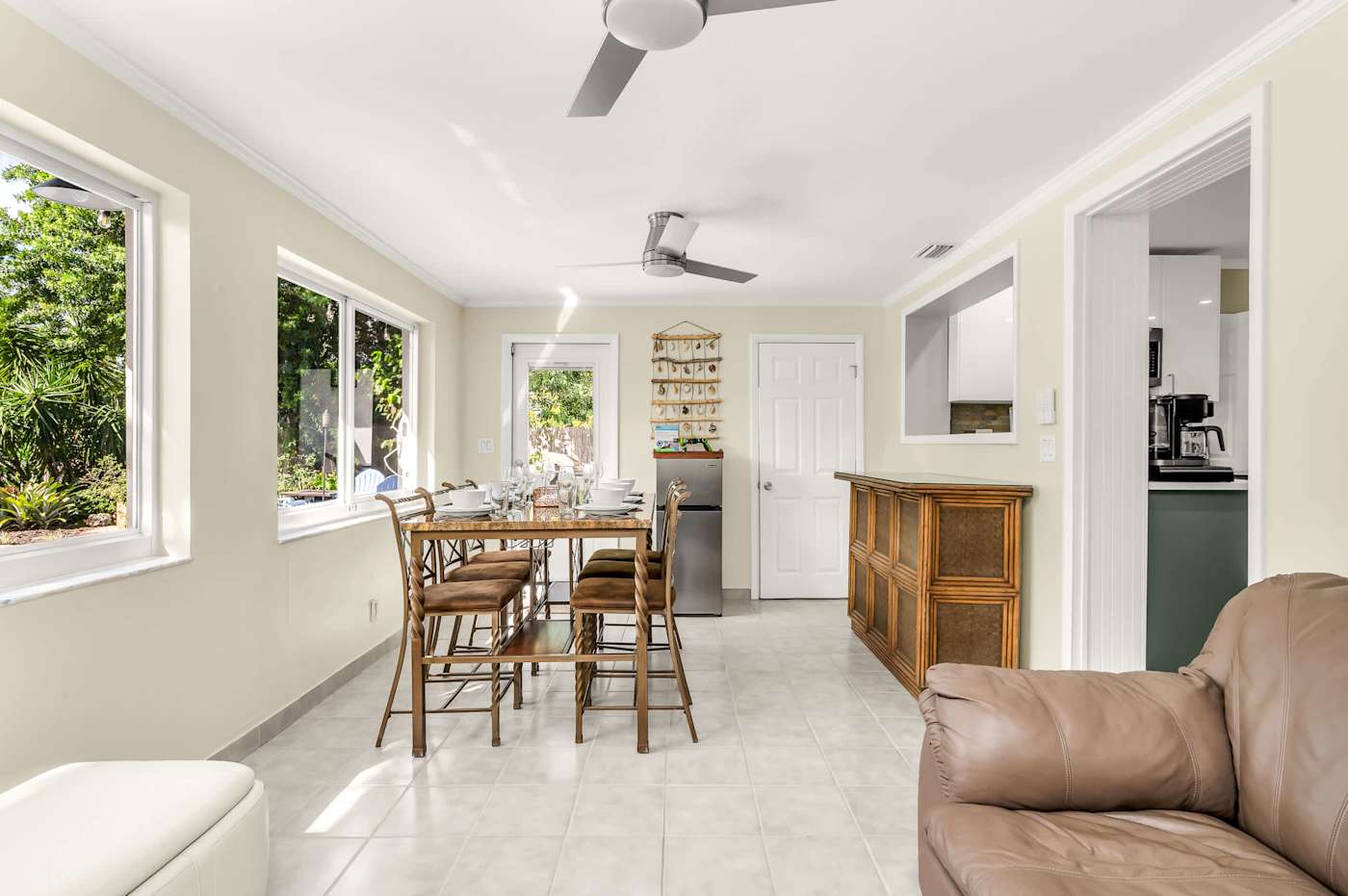 The Fairway: Sunroom with dining table, looking through to the living room