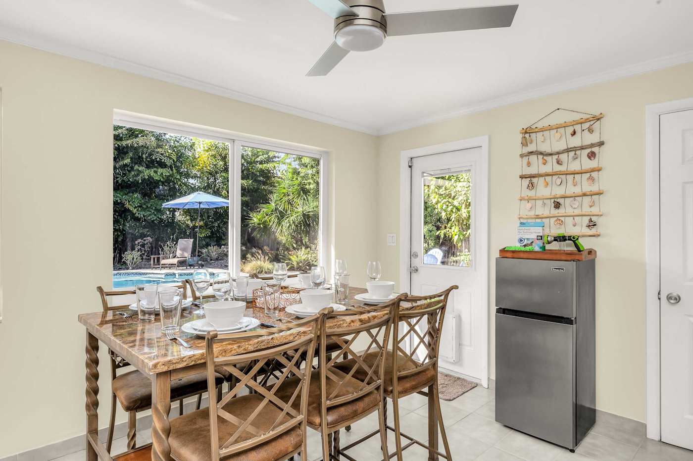 The Fairway: Dining table for six in the sunroom, with the pool through the window