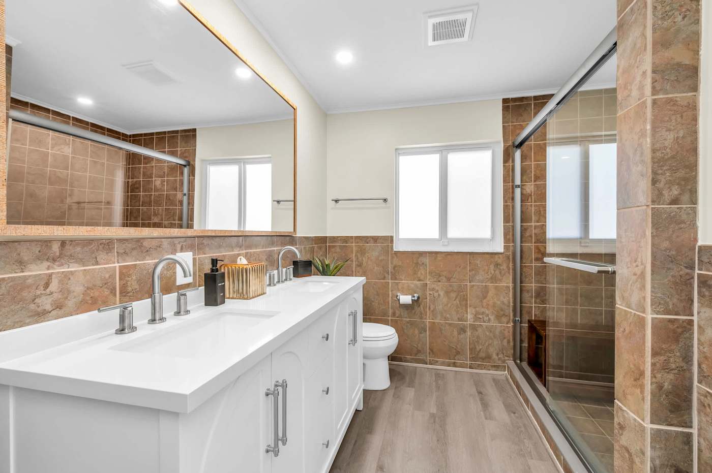 The Fairway: Bathroom with vanity, large mirror and a tiled shower