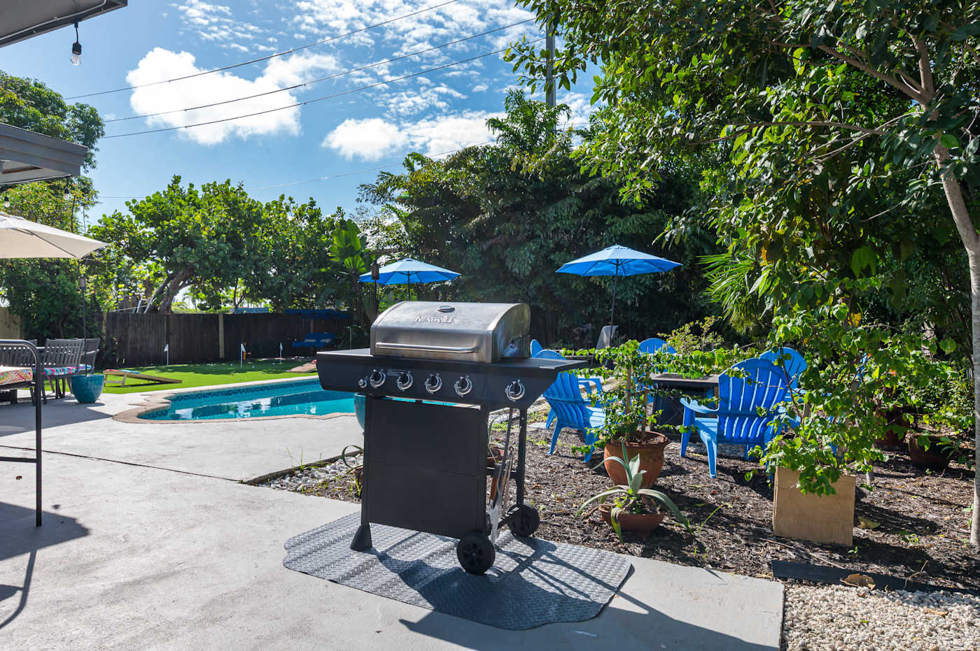 The Fairway: Gas grill on the pool deck, with seating under the parasols