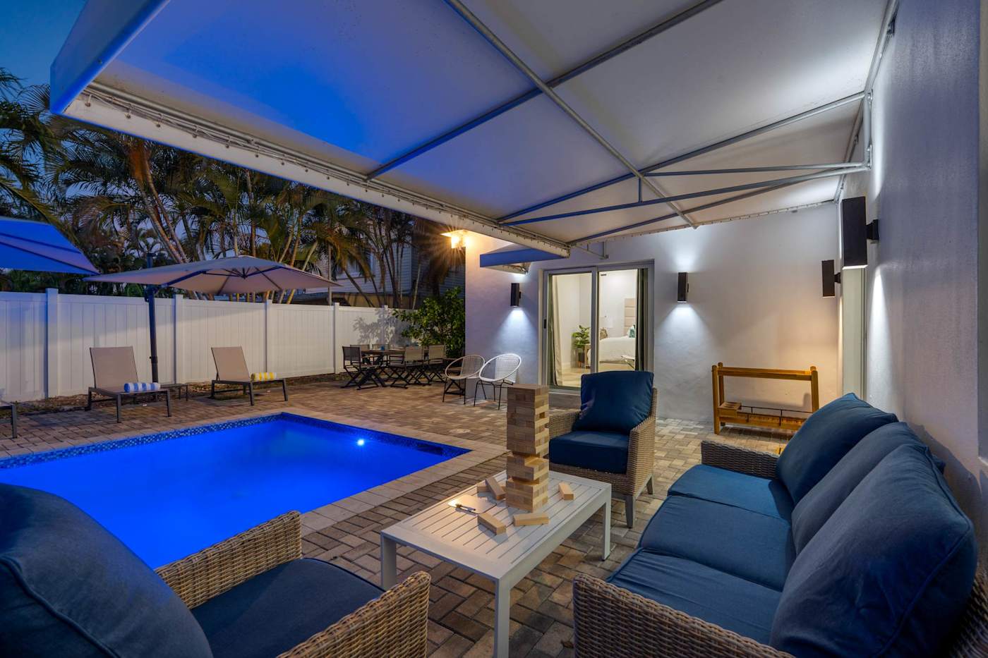 Casa Pura Vida: Pool lit blue at night, seen from the covered lounge