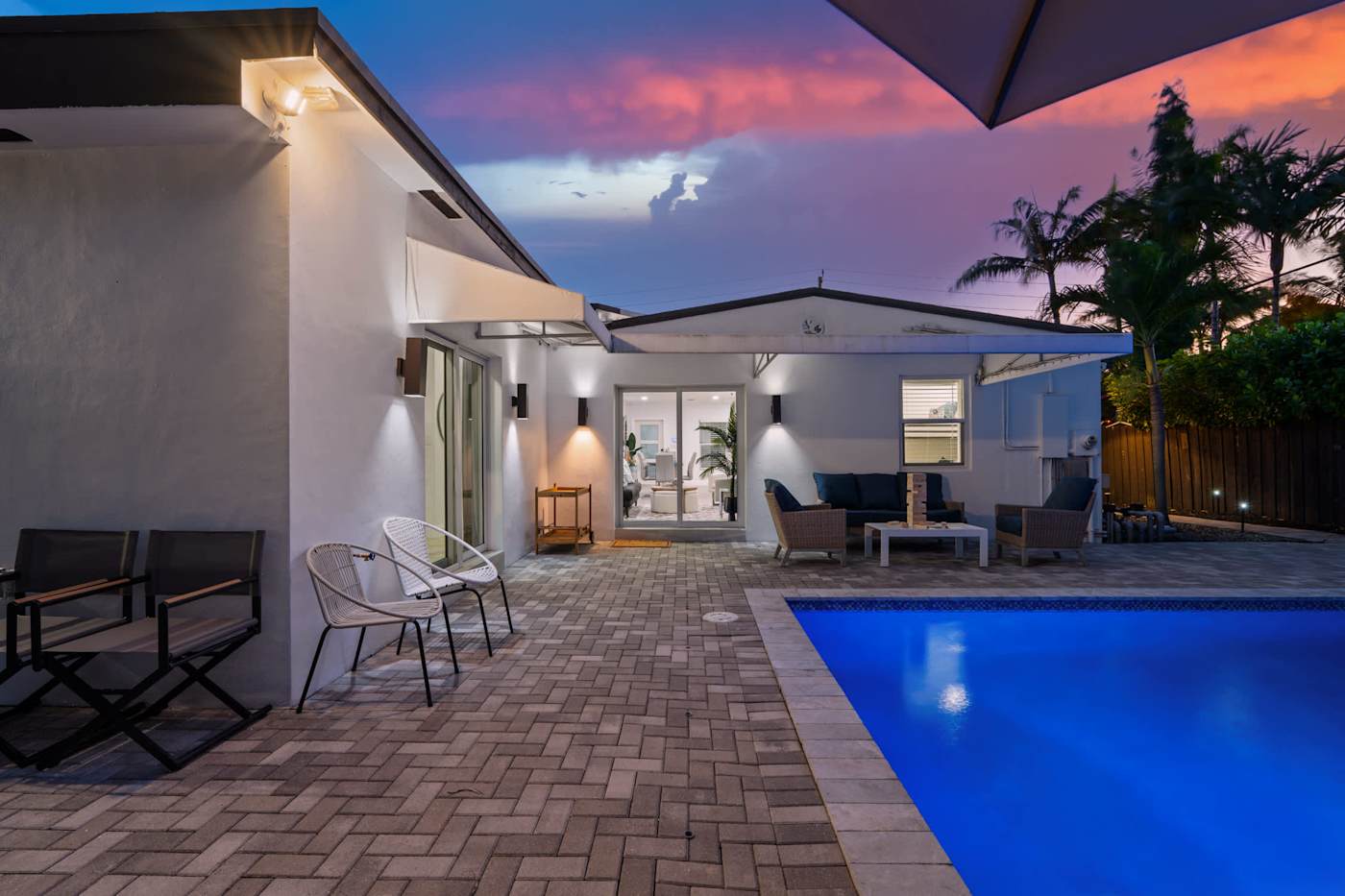 Casa Pura Vida: The house and pool lit at dusk