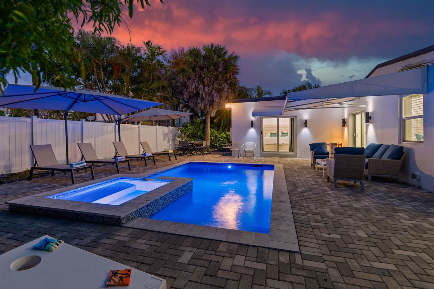 Casa Pura Vida: Heated pool and hot tub lit at dusk, seen from the garden