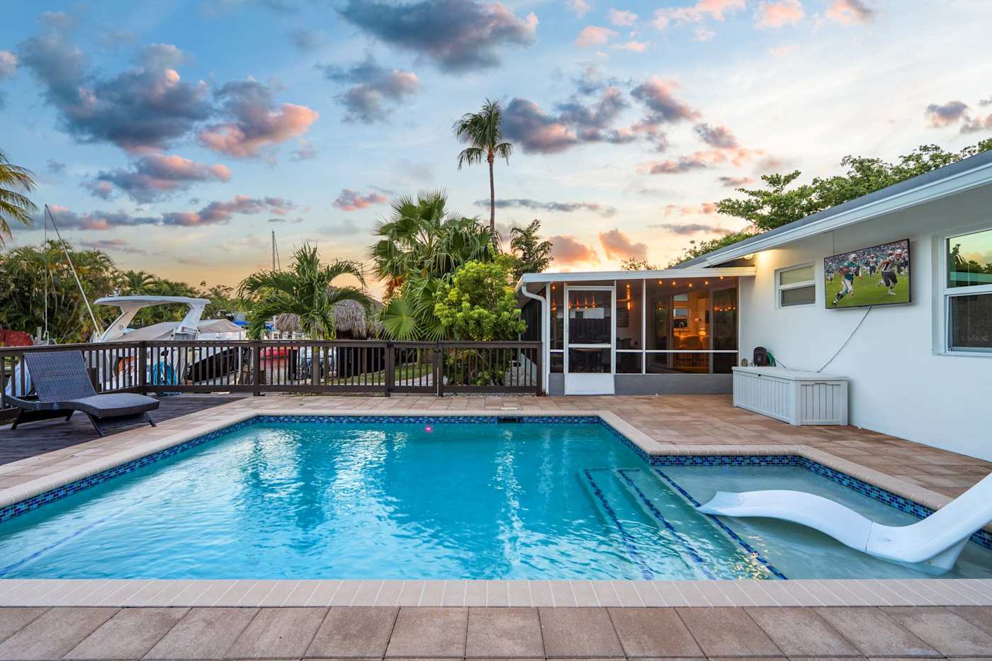 Canal House: Heated pool at sunset, with the screened porch behind