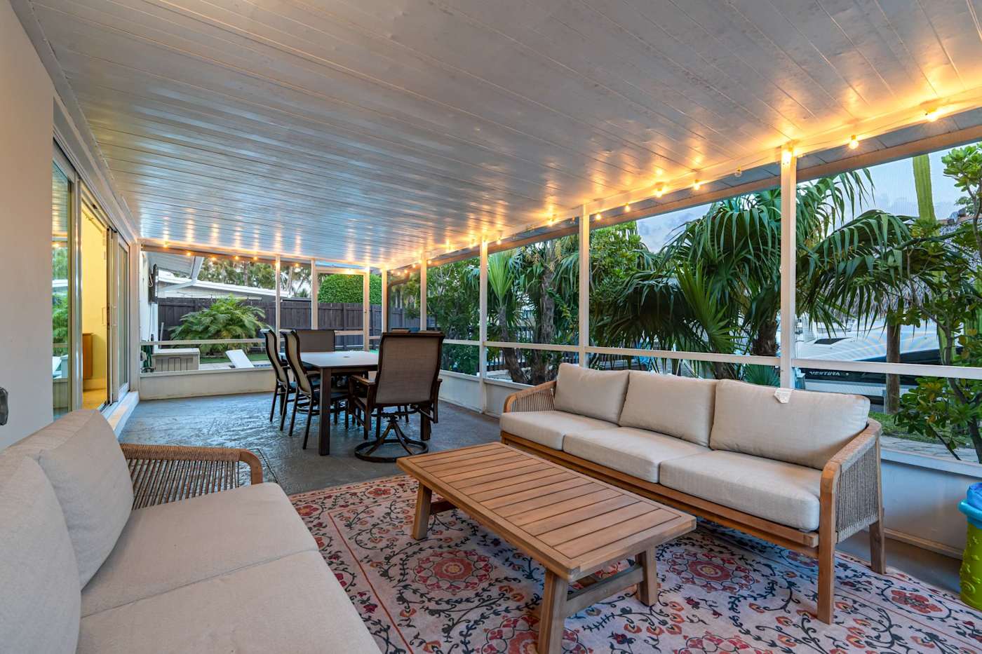 Canal House: Covered porch with sofa seating and dining, on the canal