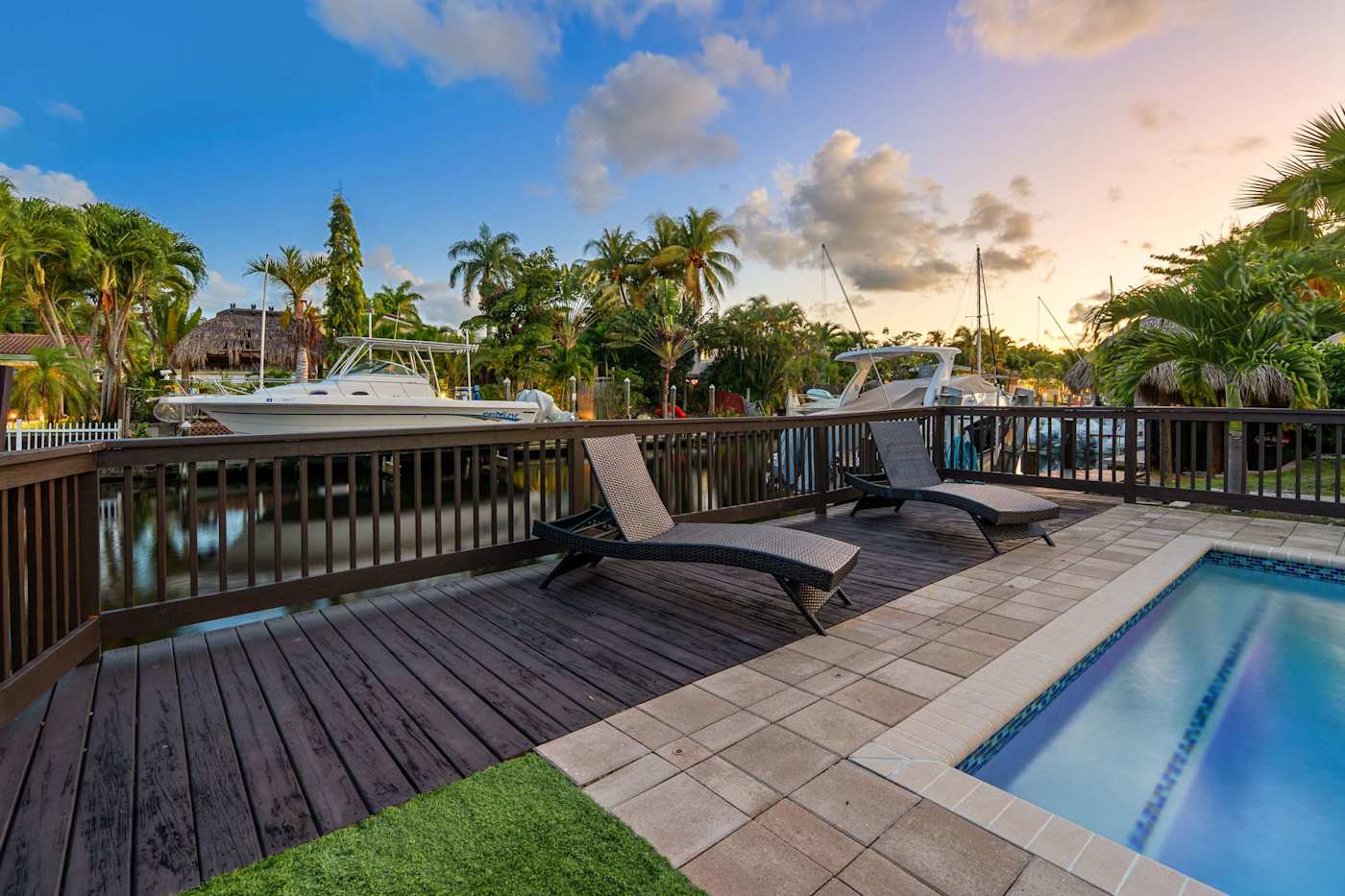 Canal House: Sun loungers on the deck beside the pool, looking to the canal