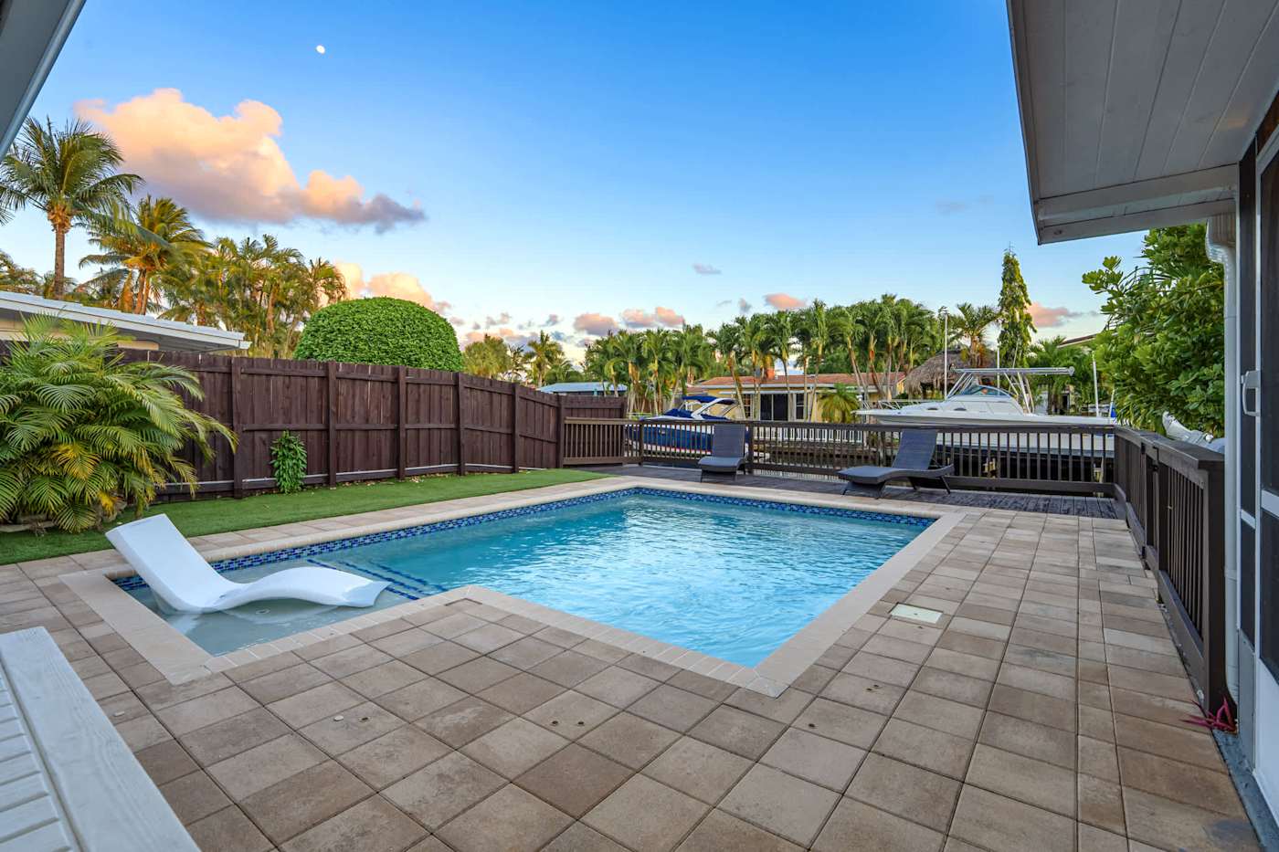 Canal House: Pool and paved deck, with the canal and boats beyond