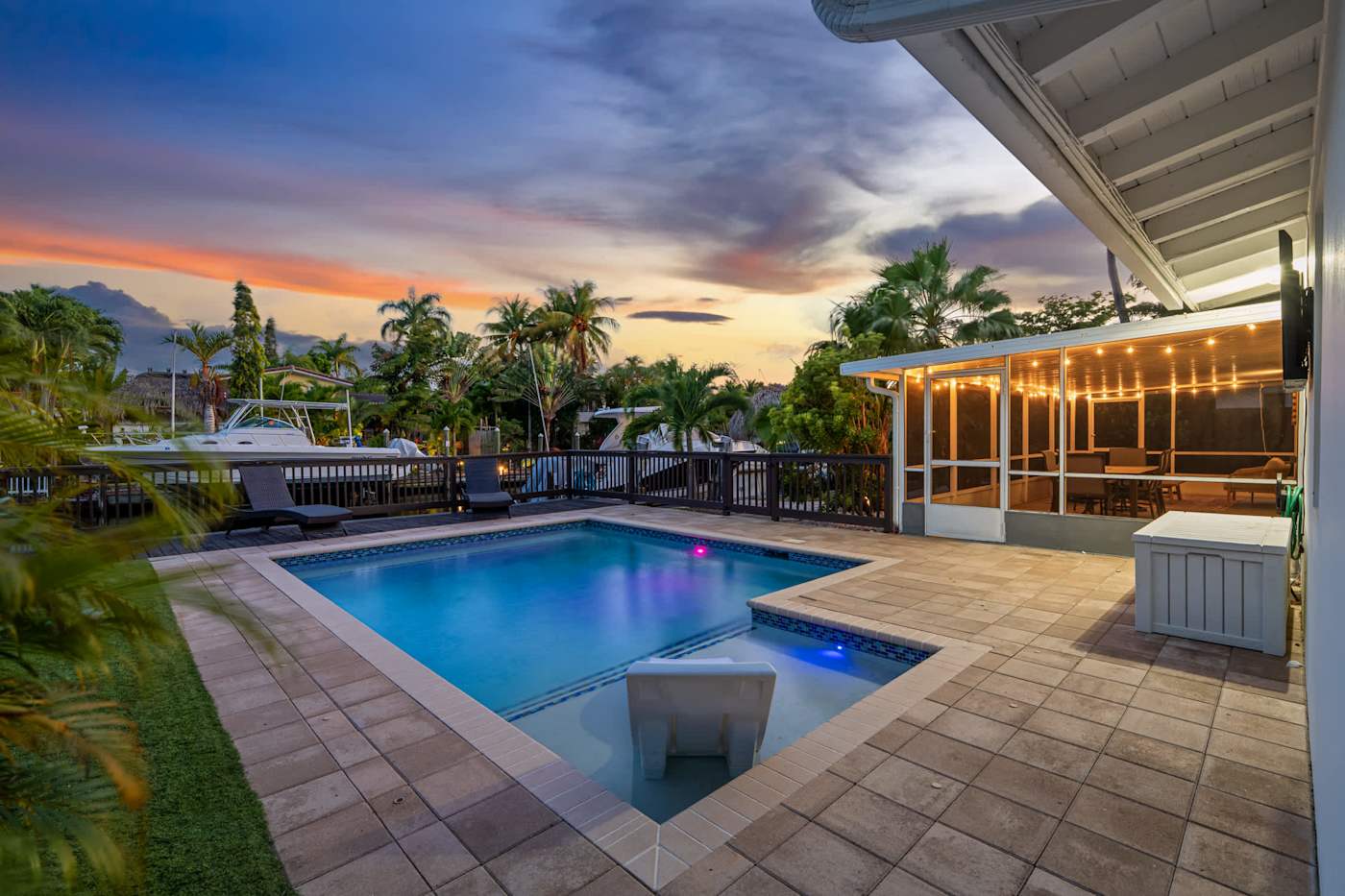 Canal House: Pool lit at dusk, with the canal and boats beyond