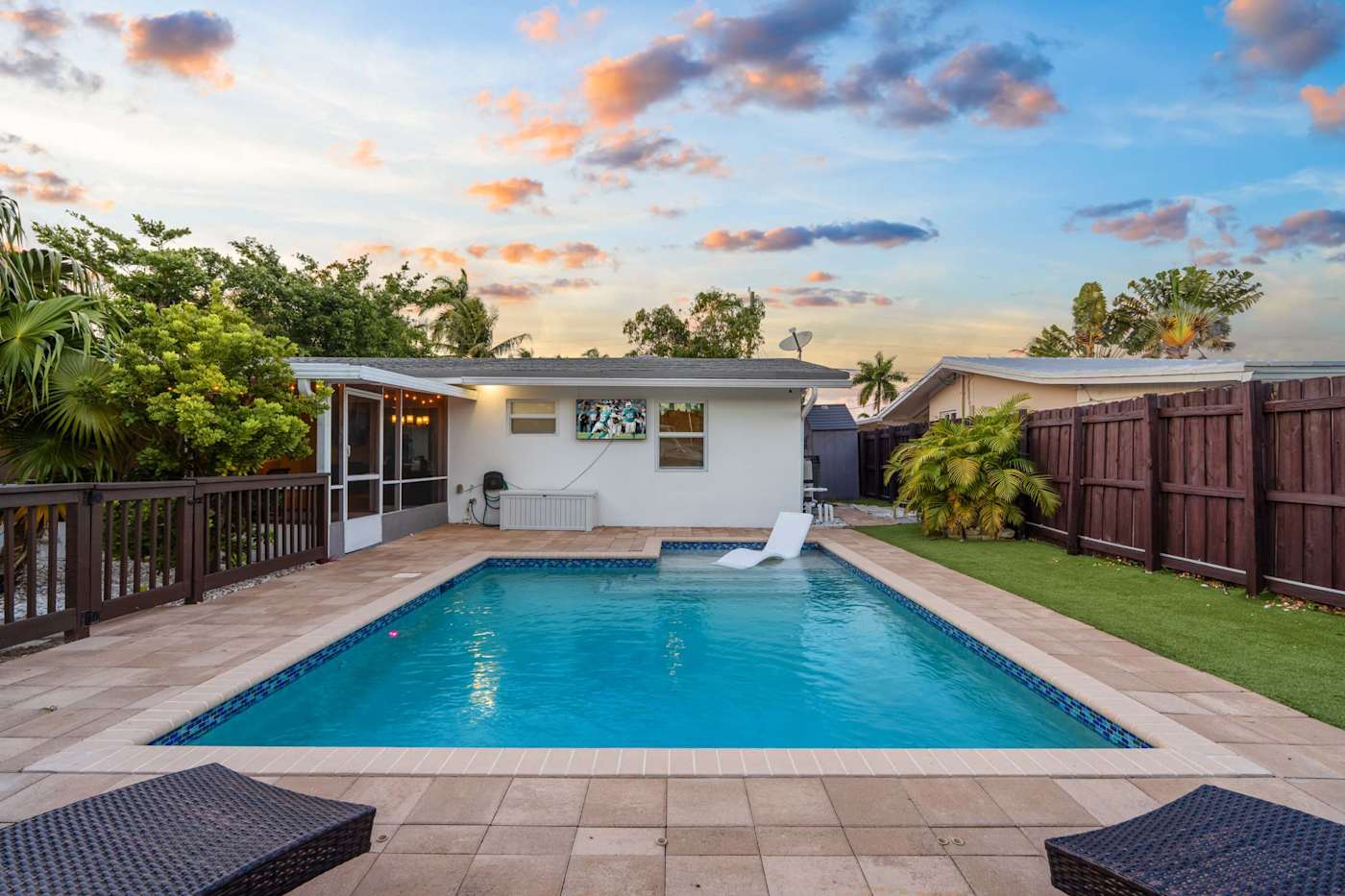 Canal House: Pool and deck at sunset, with the house lit behind