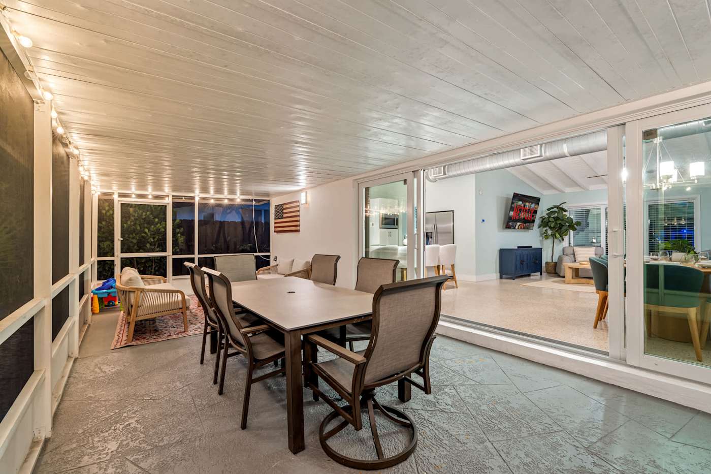Canal House: Screened porch with dining table, beside the pool