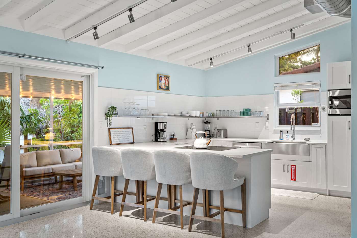 Canal House: Kitchen with island seating for four, opening to the porch