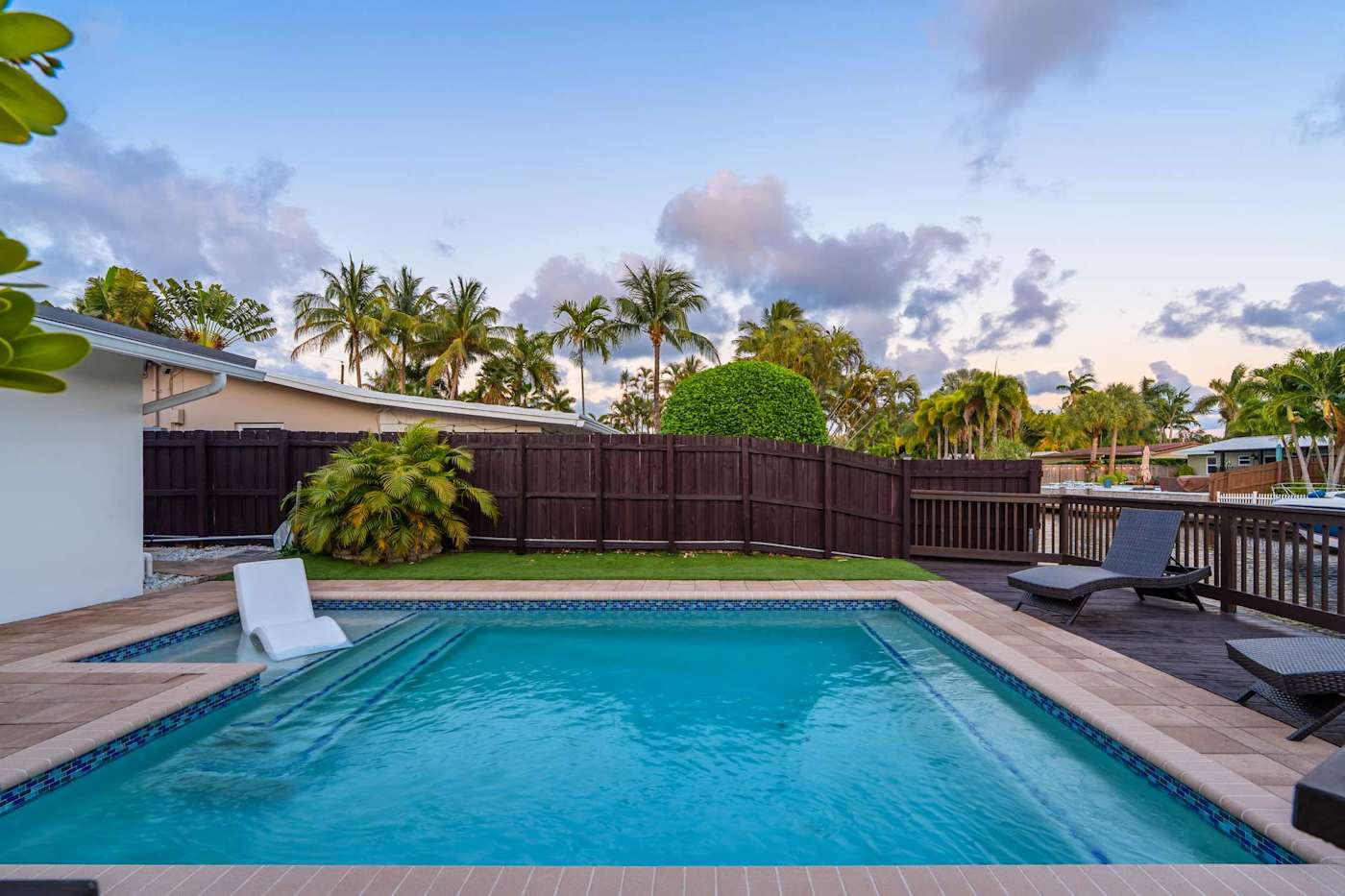 Canal House: Heated pool and deck, with the lawn and canal behind