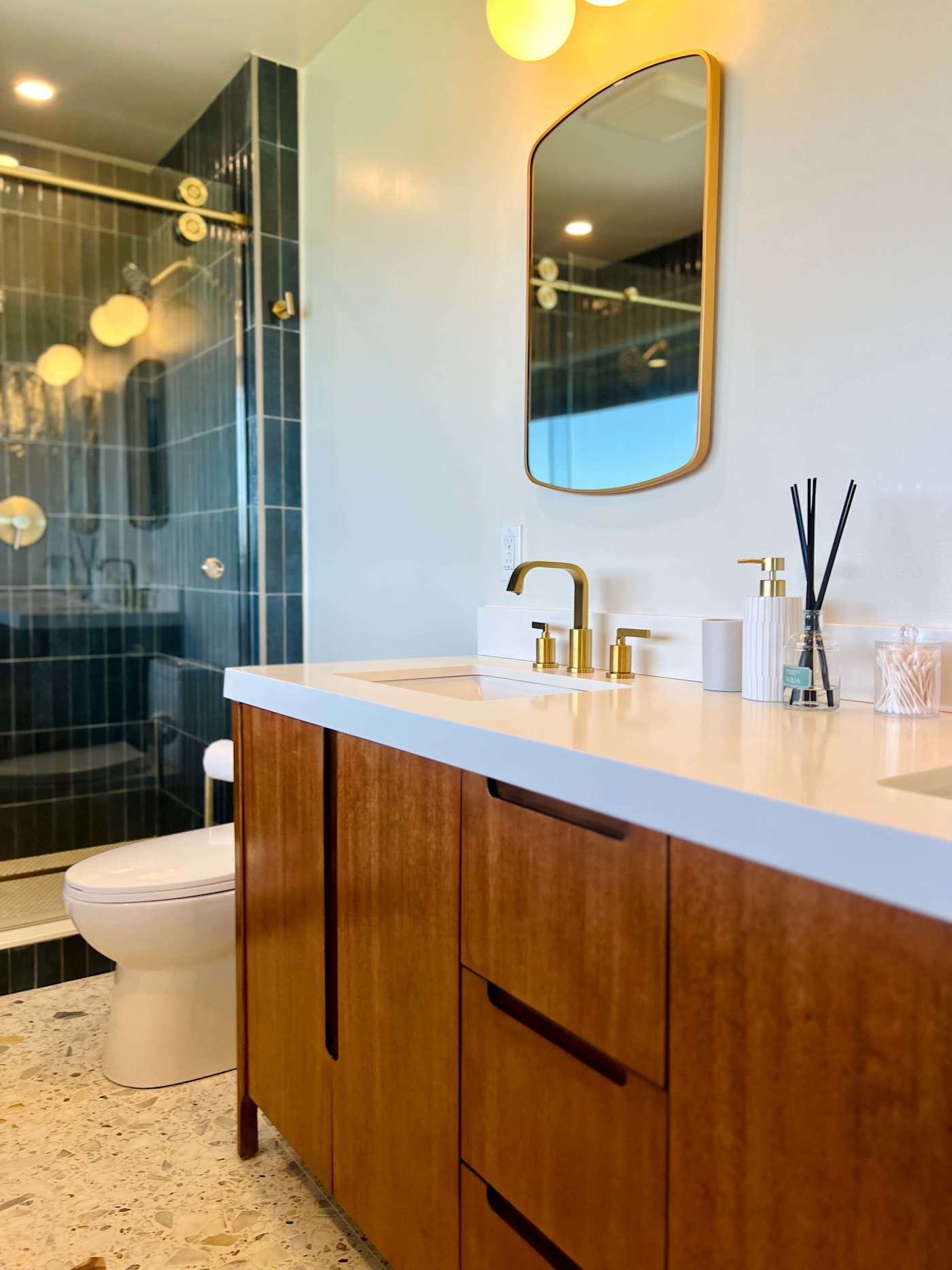 Hudson House: Bathroom double vanity with brass fixtures and tiled shower
