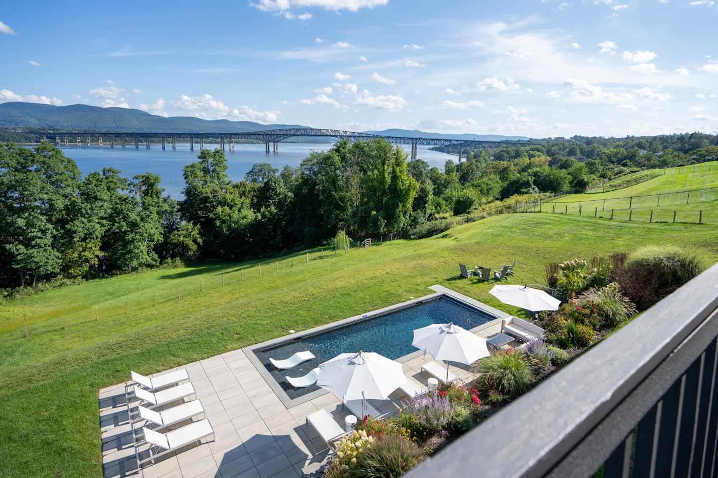 Hudson House: Pool and gardens seen from the deck above, river beyond