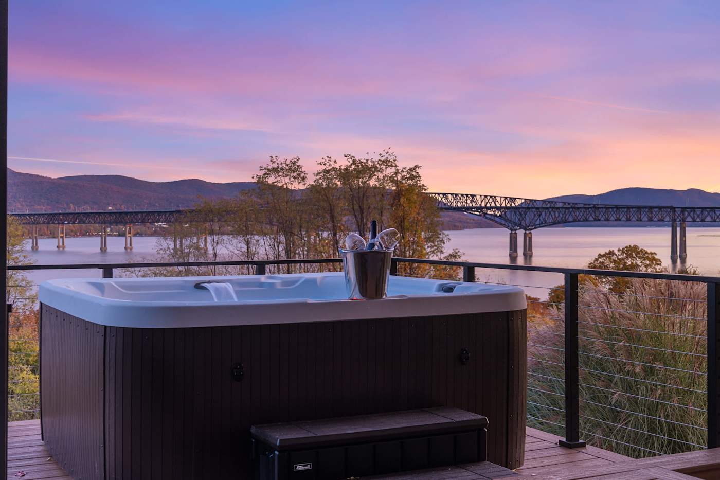 Hudson House: Hot tub on the deck at sunset overlooking the river and bridge