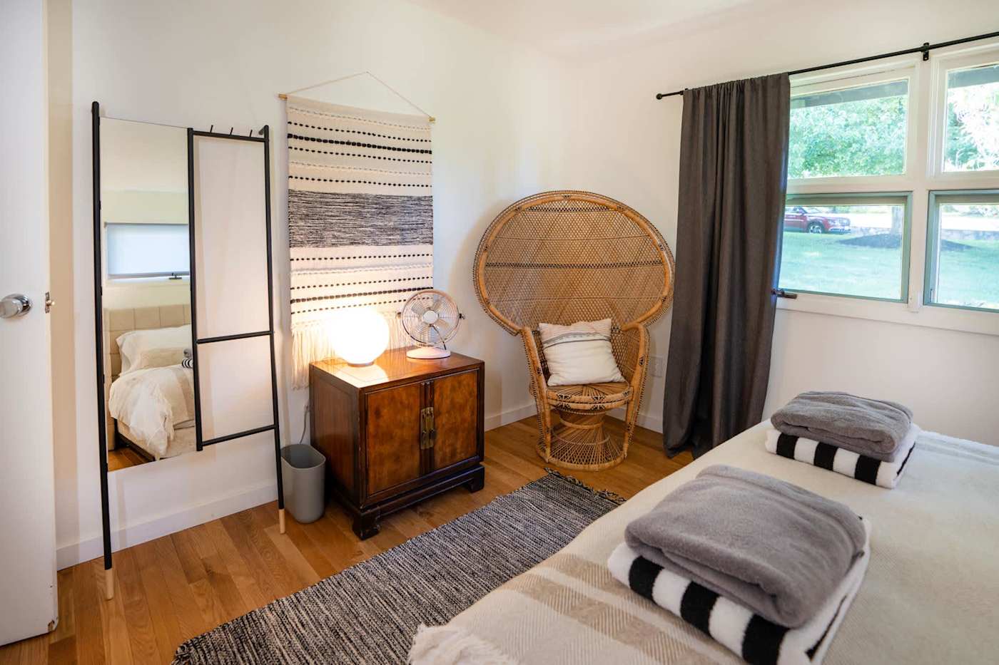Hudson House: Bright bedroom corner with peacock chair and full-length mirror