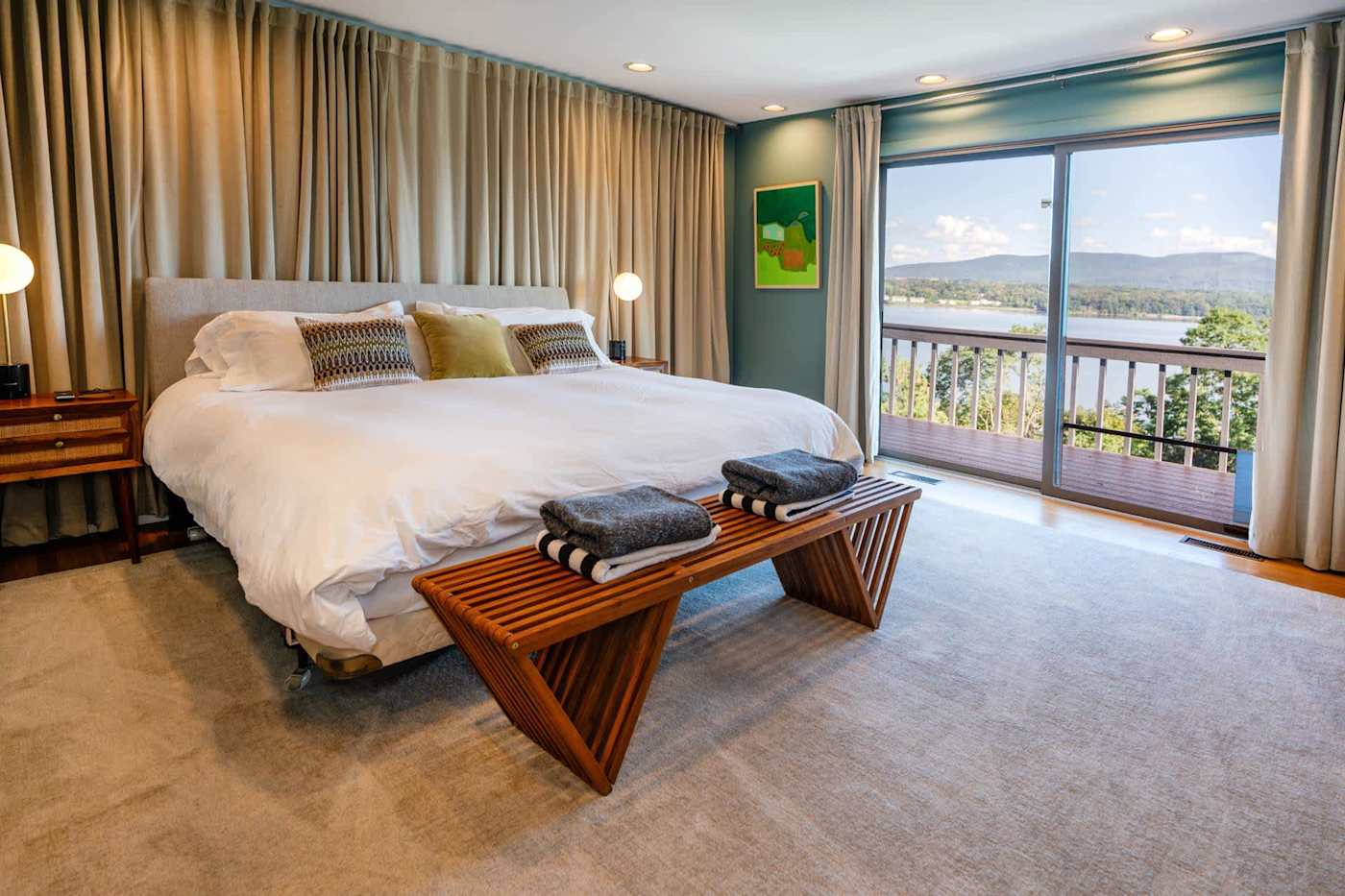Hudson House: Green-walled bedroom with sliding doors to a river-view balcony