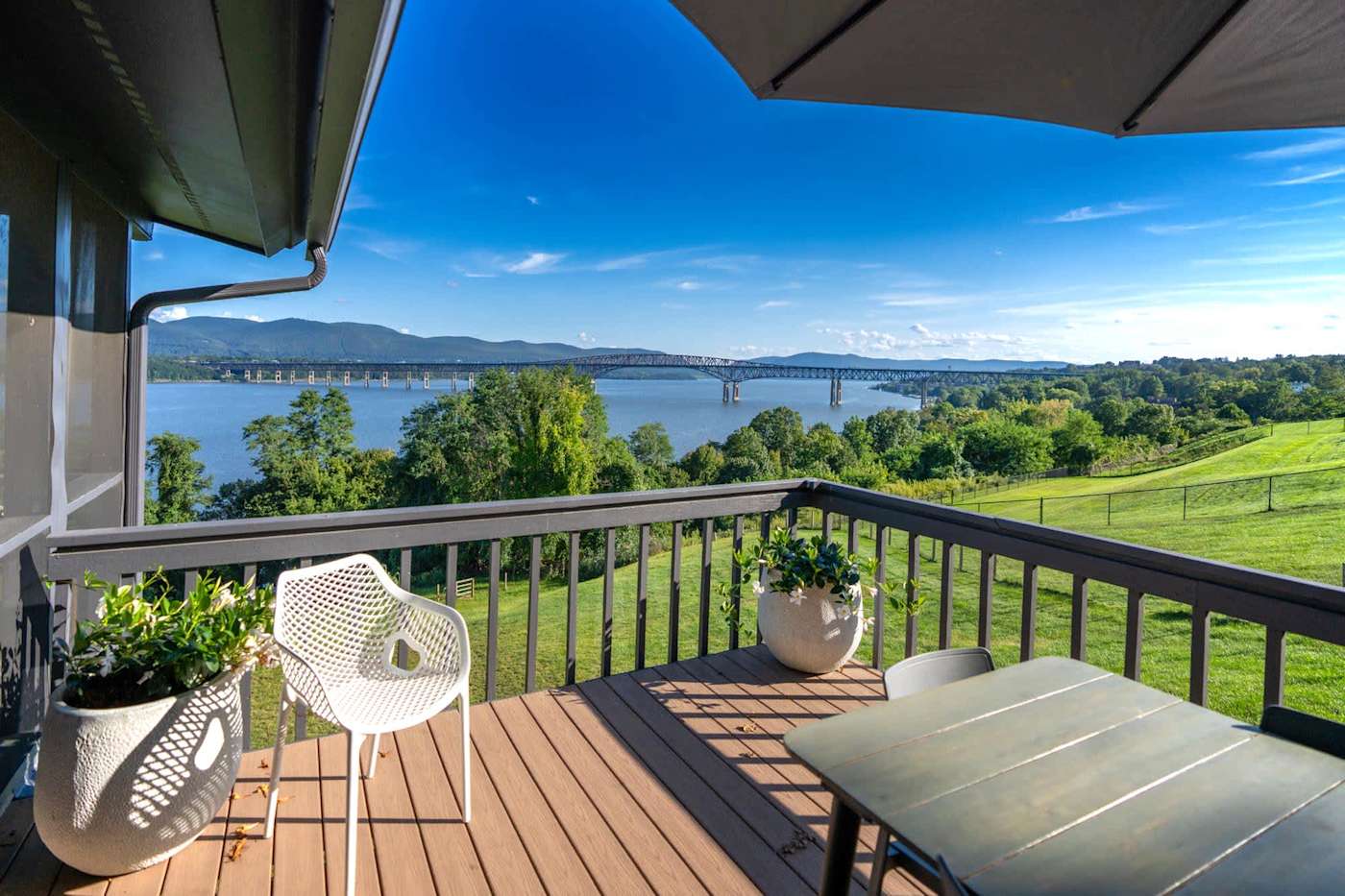 Hudson House: Deck dining table with a wide view of the river and mountains