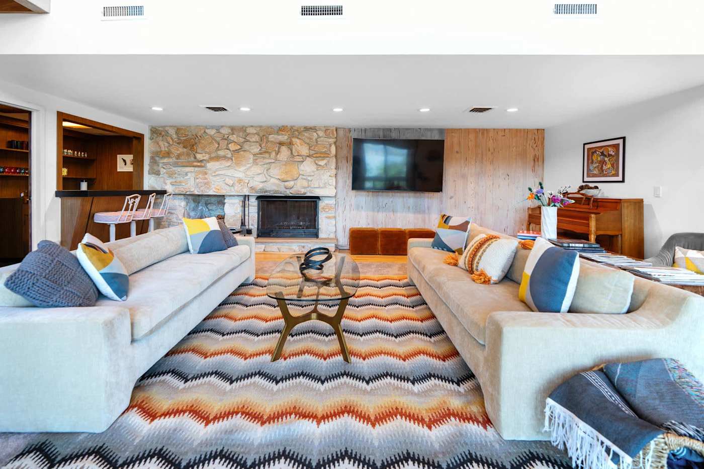 Hudson House: Living room with stone fireplace, wall TV and two sofas