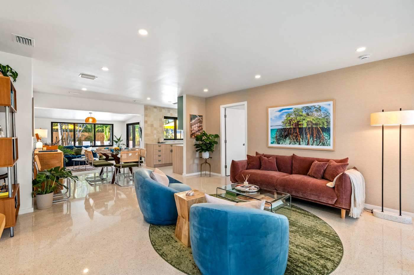 Mangrove Manor: Second living room with rust sofa, blue armchairs and a green rug