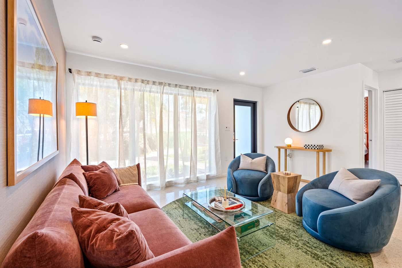 Mangrove Manor: Rust sofa and blue armchairs around a glass coffee table