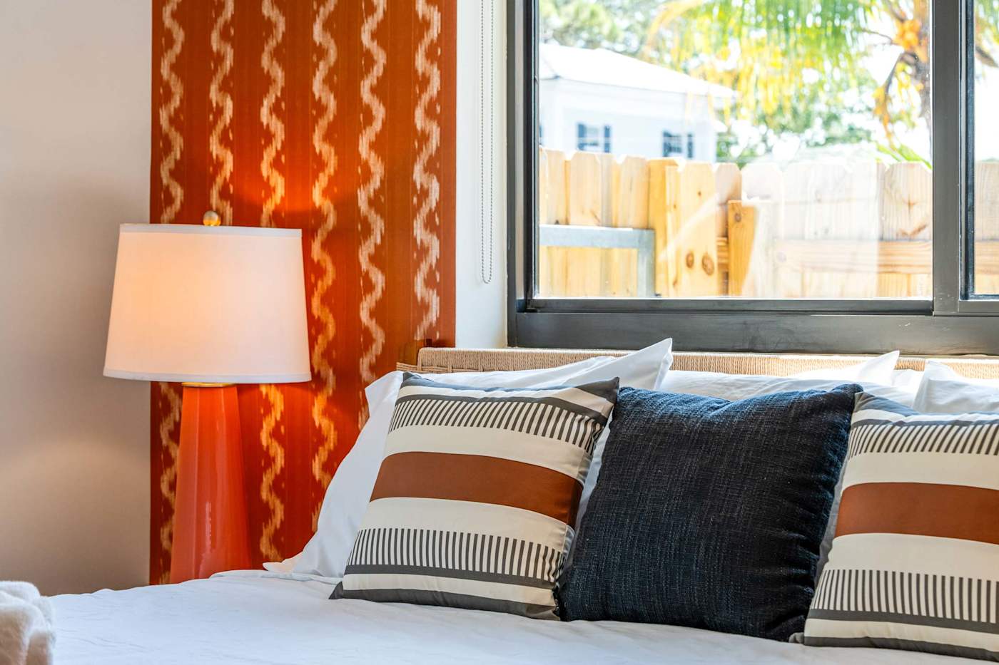 Mangrove Manor: King bed against the orange feature wall, with reading lamps either side