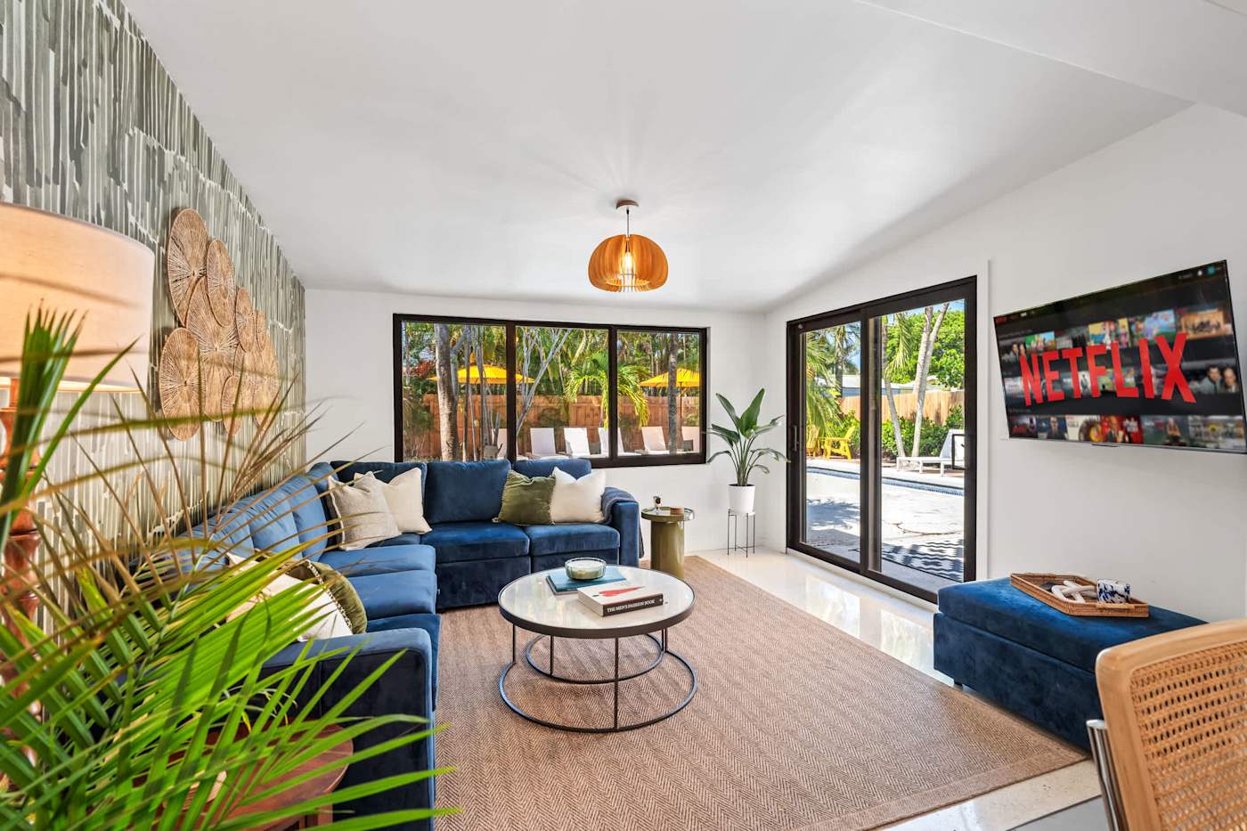 Mangrove Manor: Living room with velvet sectional, smart TV and sliding doors onto the pool deck