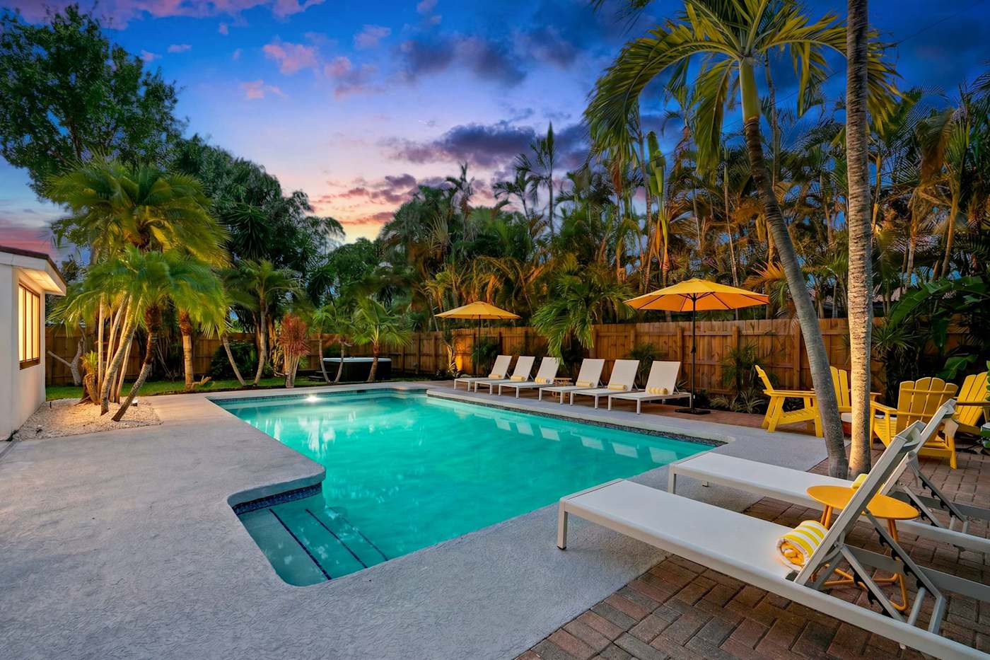 Mangrove Manor: Pool deck with loungers and Adirondack chairs at dusk