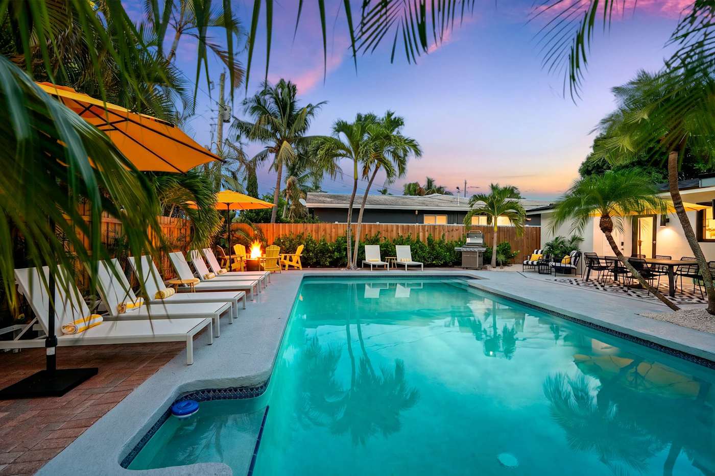 Mangrove Manor: Heated pool lit at dusk, with the deck and dining beyond