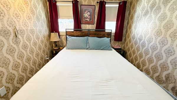 【Bedroom】Queen bed with room-darkening shades — sleep in after a summit day