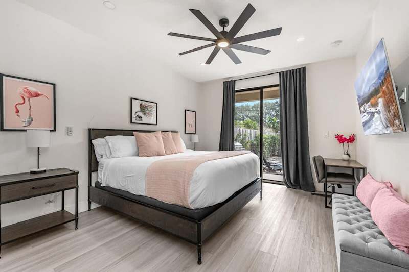 The Arcade House: Bedroom with king bed, desk and sliding doors to the patio