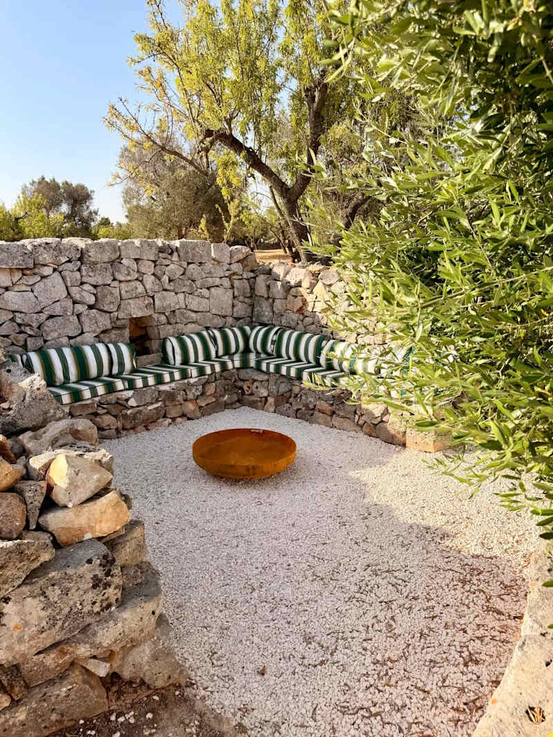 Trullo Ostro: Sunken stone fire pit lounge with cushioned built-in bench